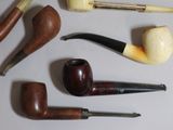 many different types of smoking pipes and pipes on the table