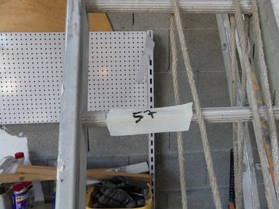 une échelle sur laquelle est accrochée une pancarte, dans un garage
