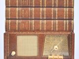 des livres empilés les uns sur les autres, avec une radio posée devant