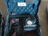 une caisse à outils bleue avec des outils sur le sol