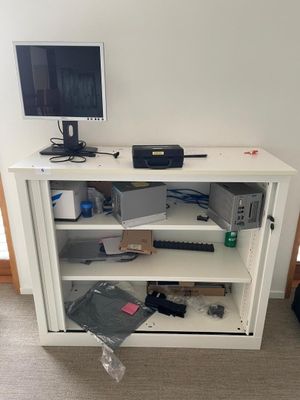 a white cabinet with a computer on top of it
