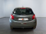 the back of a silver car in a room with a white wall