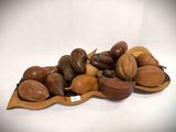 a pile of nuts on a wooden plate on a table