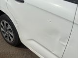 a small white car parked on the side of the road