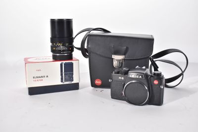 a black camera and a black bag on a white table