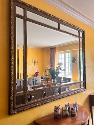 un miroir accroché au mur au-dessus d'une table dans une pièce