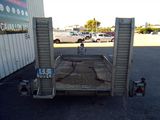 a small trailer with a ramp in the middle of a parking lot