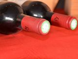 two bottles of wine sitting on a red cloth