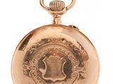 an antique gold pocket watch with a chain on a white background