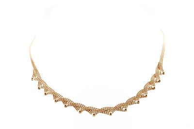 gros plan d'un collier en or sur fond blanc
