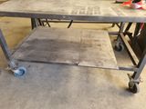 a metal table with wheels on it in a garage