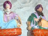 deux figurines représentant un homme et une femme assis sur un canapé