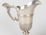 an antique silver plated pitcher with a handle on a pedestal