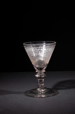 a close up of a wine glass on a table with a black background