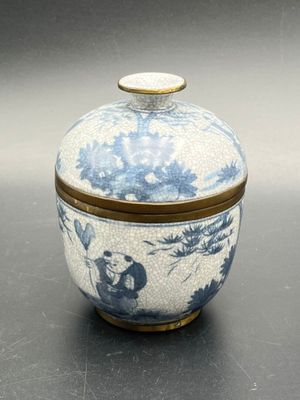 a blue and white jar with a lid on a table