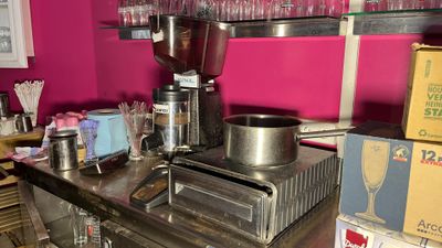 a counter with a coffee maker and cups on it