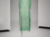 an image of a green dress on a mannequin stand in a room