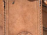 a brown leather bag with a tag attached to it