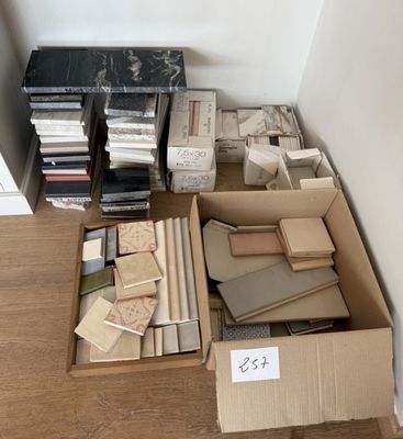 une boîte remplie de livres posée par terre à côté d'une pile de livres
