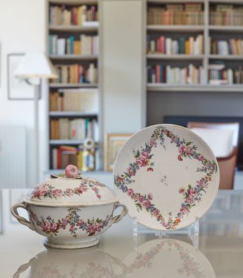 a white table with a bowl and a plate on it