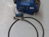 un tuyau bleu et une machine bleue posés sur une table blanche