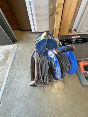 une photo d'un tuyau bleu posé par terre à côté d'une boîte à outils