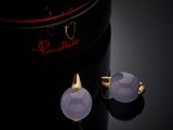 a pair of purple glass stud earrings sitting on top of a black box