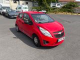 une voiture rouge garée dans un parking