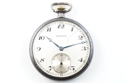 une montre de poche en argent sur une surface blanche