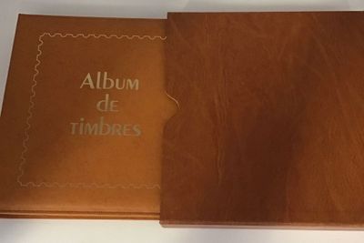 Un album de timbres s'ouvre sur une surface blanche
