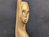 a gold statue of a cat sitting on a black surface