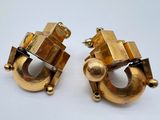 paire de boucles d'oreilles dorées ornées de motifs géométriques sur fond blanc
