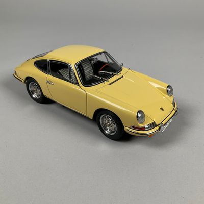yellow model of a car on a white surface with a gray background