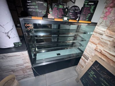 a glass display case in a restaurant with menus on the wall