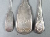 three spoons and a spoon rest on a gray surface