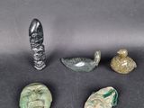 a group of four pieces of glass and metal on a black surface