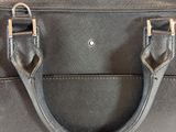 grey leather handbag with metal handles on a white surface