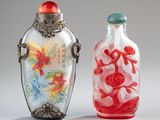 two glass bottles with different colored designs on them