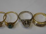 three gold rings with emerald and ruby stones