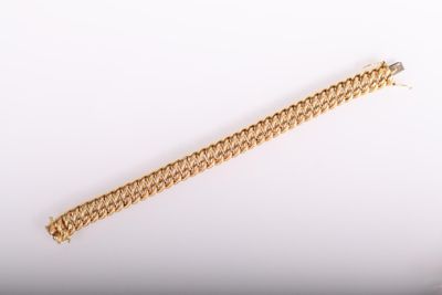 a close up of a gold bracelet on a white surface