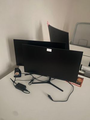 deux écrans posés sur un bureau, avec une souris et un clavier