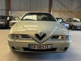 a silver car parked in a garage next to other cars