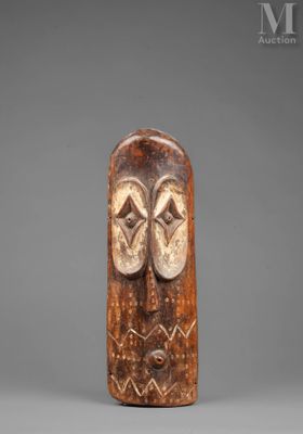 a carved wooden mask with two eyes and a nose