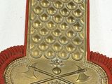 a red and gold chair with a gold plate on it