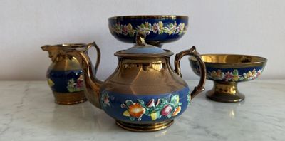 un service à thé bleu et or posé sur une table en marbre