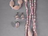 necklace, bracelet, and ring with pink beads on a gray surface