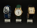 trois montres sont alignées les unes à côté des autres sur une surface noire