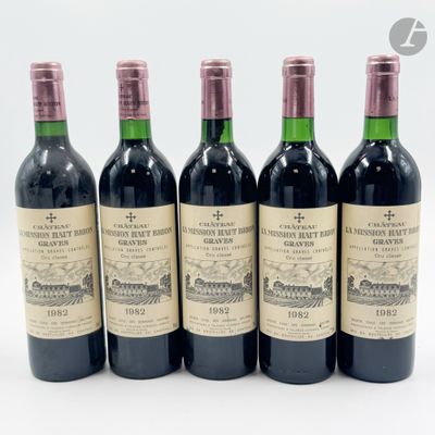 quatre bouteilles de vin sont alignées sur une surface blanche