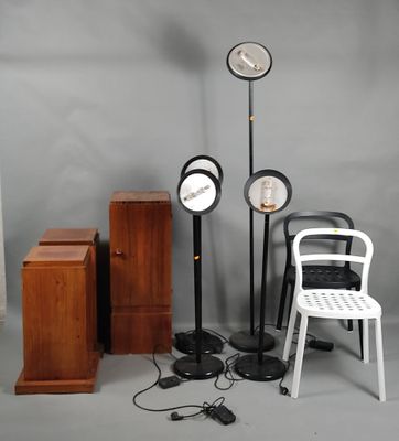 a white chair sitting next to a white chair and a clock on a stand