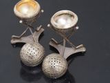 two silver candlesticks on top of a table